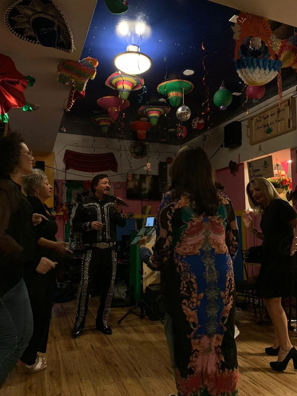 A mariachi singer performing among guests in Hacienda Santa Teresa’s dining room