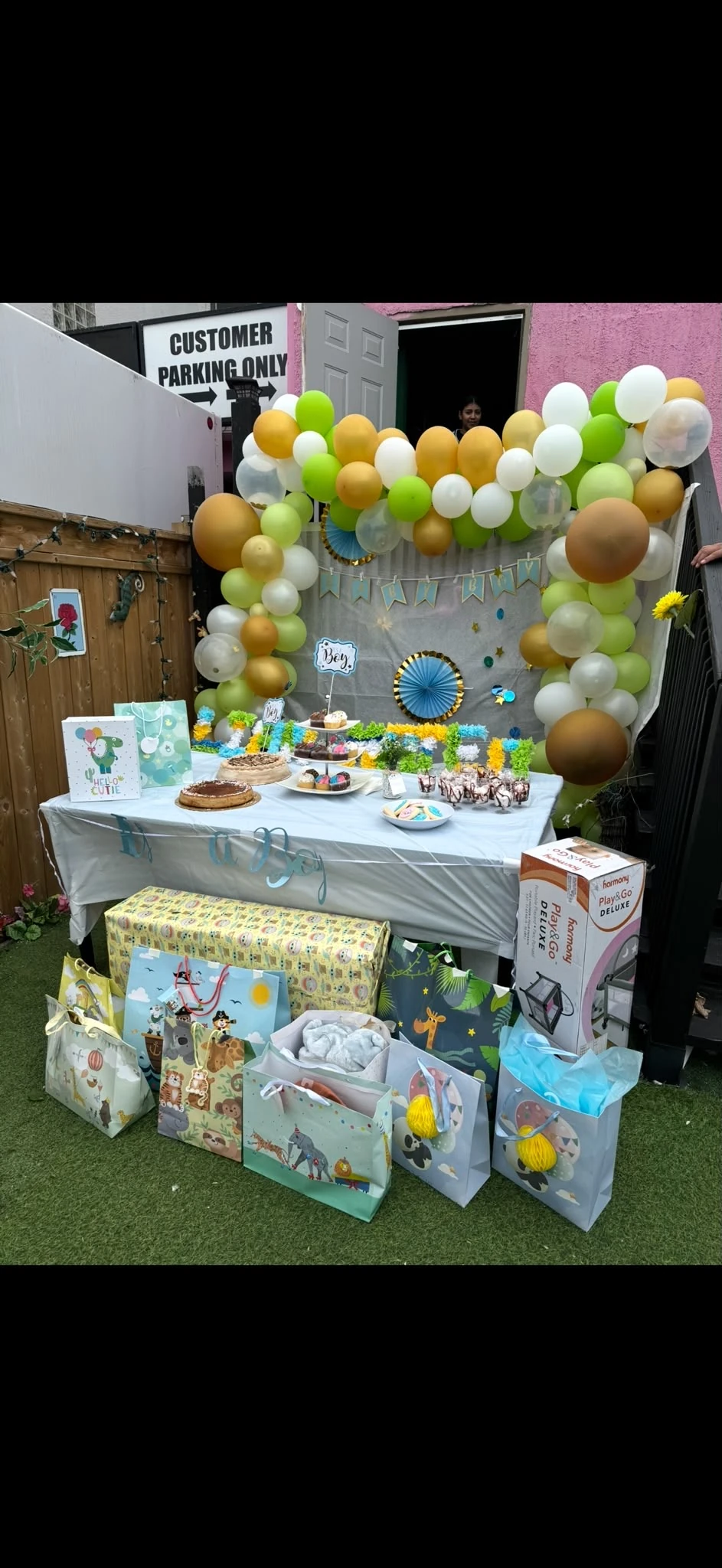 A baby-shower dessert table, gifts, and balloon arch on Hacienda Santa Teresa’s patio