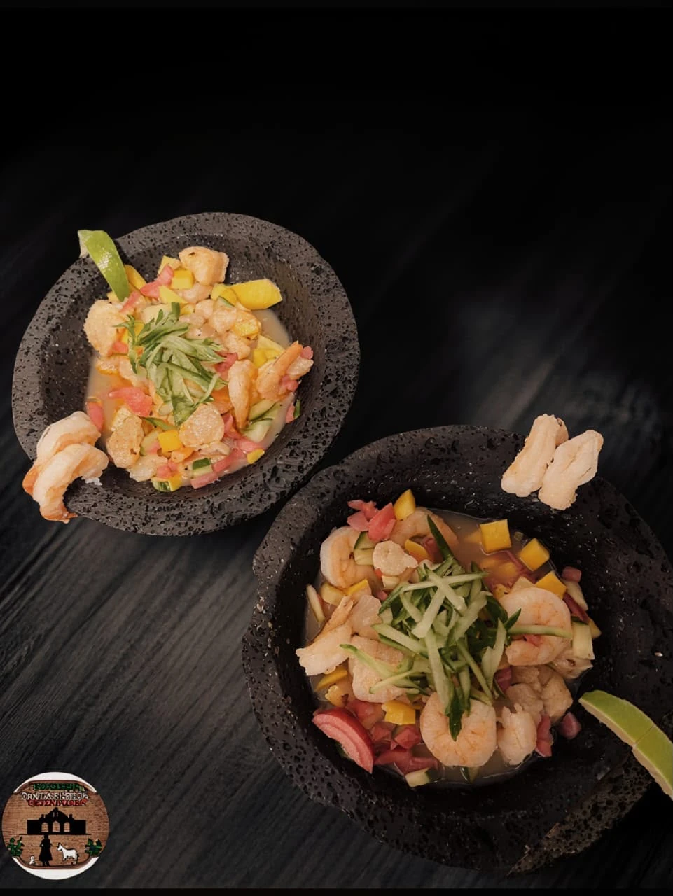 Two black bowls of shrimp with colourful diced vegetables, lime, and crisp garnishes at Hacienda Santa Teresa