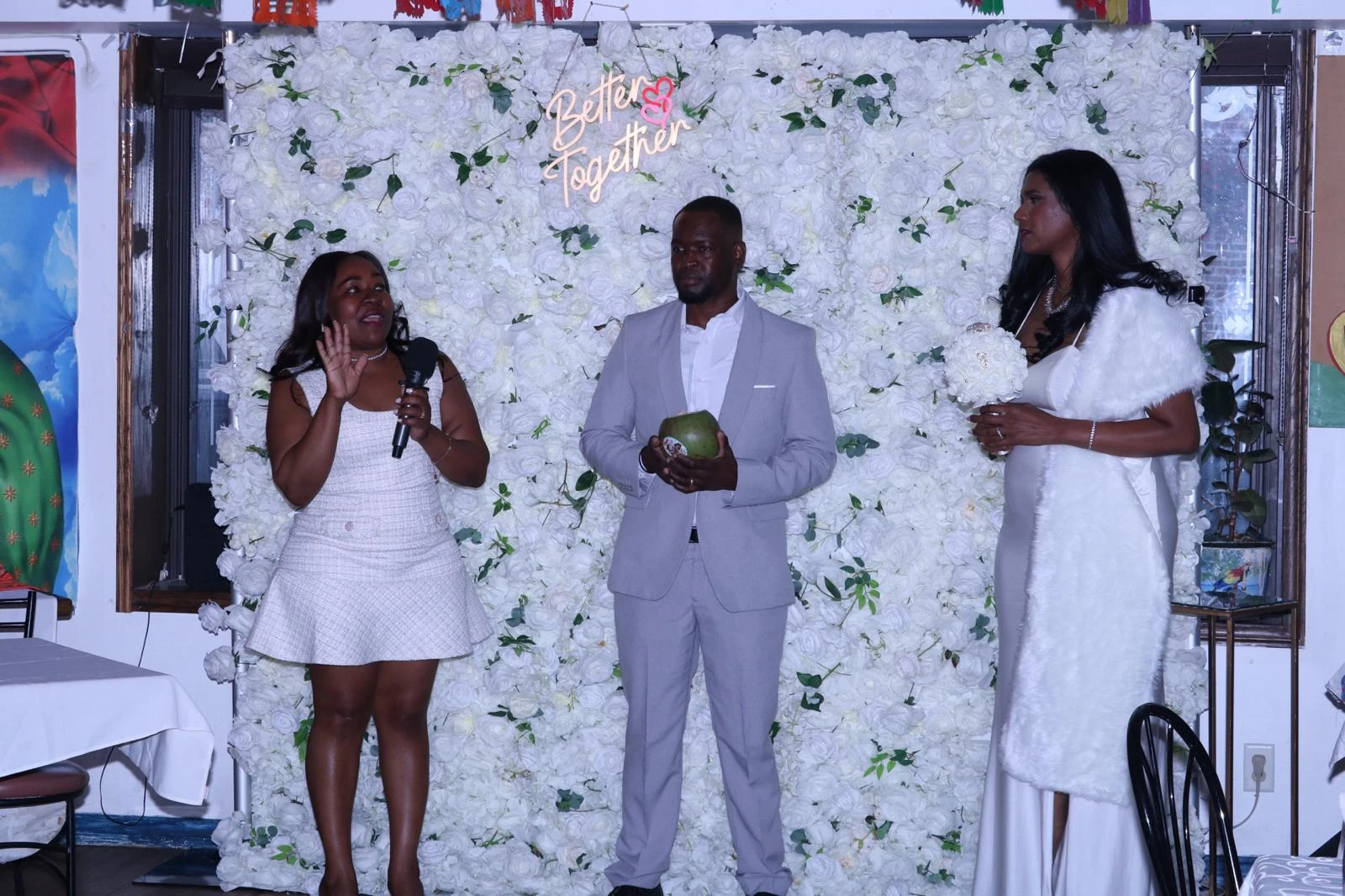 Wedding guests standing before a white floral backdrop with a Better Together sign at Hacienda Santa Teresa