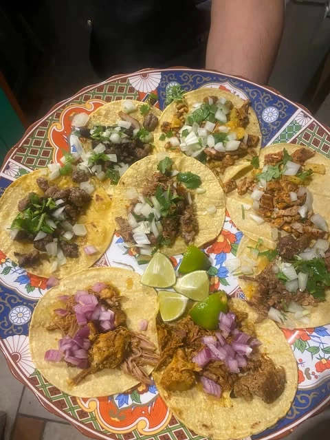 A colourful platter of tacos topped with onions and cilantro, served with lime at Hacienda Santa Teresa