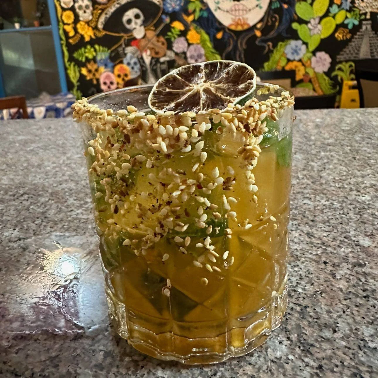 A signature Hacienda cocktail in front of Mexican artwork